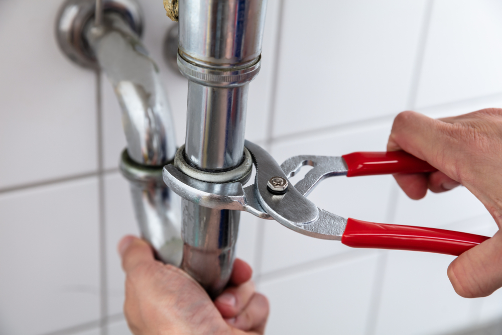 Close-up,Of,A,Plumber's,Hand,Repairing,Sink,With,Adjustable,Wrench