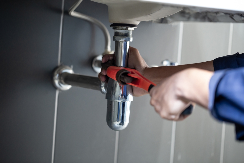 Plumber,Uses,Wrench,To,Repair,Water,Pipe,Under,Sink,There